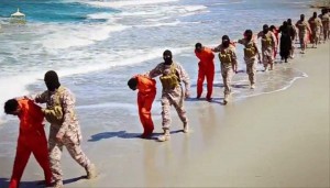 EDS NOTE: GRAPHIC CONTENT - This undated image made from a video released by Islamic State militants, Sunday, April 19, 2015, appears to show the killing of a group of captured Ethiopian Christians in Libya.  The 29-minute video released online Sunday purportedly shows two groups of captives. It says one group is held by an IS affiliate in eastern Libya and the other by an affiliate in the south. A masked fighter delivers a long statement before the video switches between footage that purportedly shows the captives in the south being shot dead and the captives in the east being beheaded on a beach. (Militant video via AP)