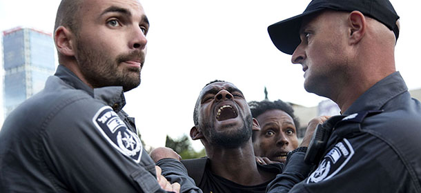 Israeli police officers detain an Israeli Ethiopian during a demonstration in Tel Aviv, Sunday, May 3, 2015. Several thousand people, mostly from Israel's Jewish Ethiopian minority, protested in Tel Aviv against racism and police brutality on Sunday shutting down a major highway and scuffling with police. (AP Photo/Tsafrir Abayov)