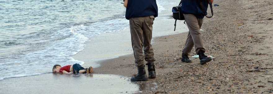 WCENTER 0XPJACQEIM                epa04909154 Turkish gendarmerie stand near by the washed up body of a refugee child who drowned during a failed attempt to sail to the Greek island of Kos, at the shore in the coastal town of Bodrum, Mugla city, Turkey, 02 September 2015. At least 11 Syrian migrants died in boat sank after leaving Turkey for the Greek island of Kos.  EPA/DOGAN NEWS AGENCY  ATTENTION EDITORS: PICTURE CONTAINS GRAPHIC CONTENT ; TURKEY OUT