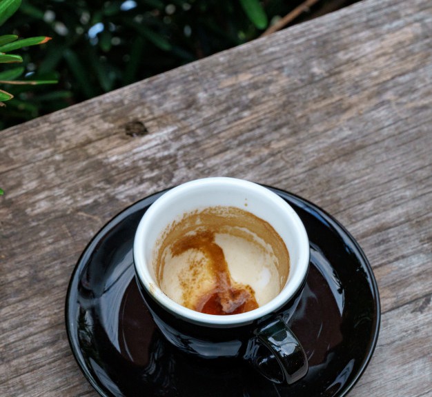 coffee-cup-wooden-table-black-coffee-stains-cup-background-selective-focus_7423-96